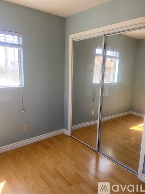 A room with a sliding glass door and wooden flooring.