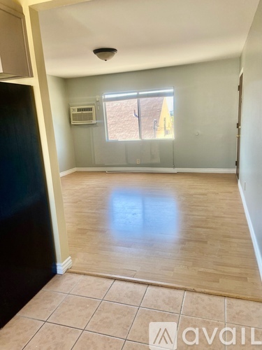 A room with a tiled floor and a window with a view of a building outside.