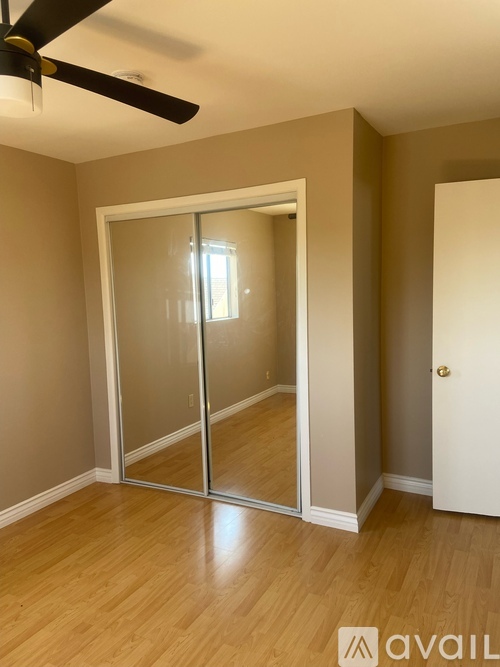 A room with a sliding glass door and a ceiling fan.