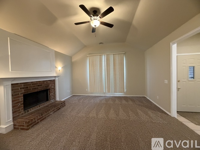 A living room with a fireplace and carpeted floor.