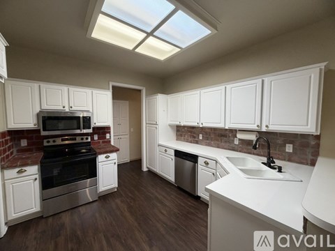 A kitchen with white cabinets and a brick backsplash.