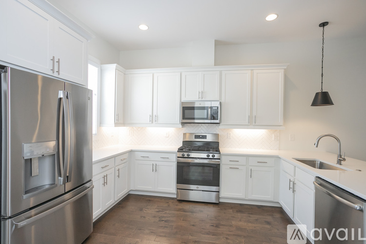 A modern kitchen with white cabinets and stainless steel appliances.