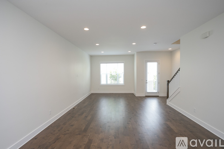 A spacious room with wooden floors and white walls.