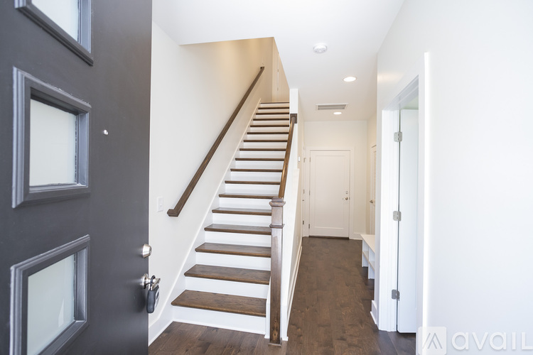 A staircase with wooden steps and a dark grey door.