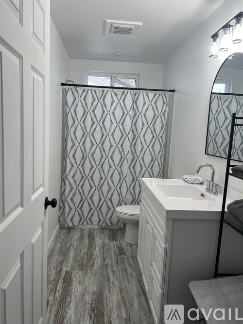 A bathroom with a diamond pattern shower curtain.