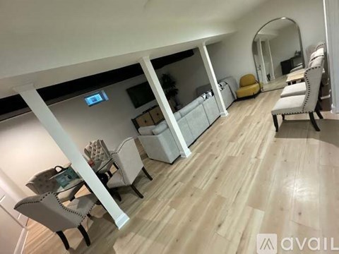 A living room with a white couch and a yellow chair.