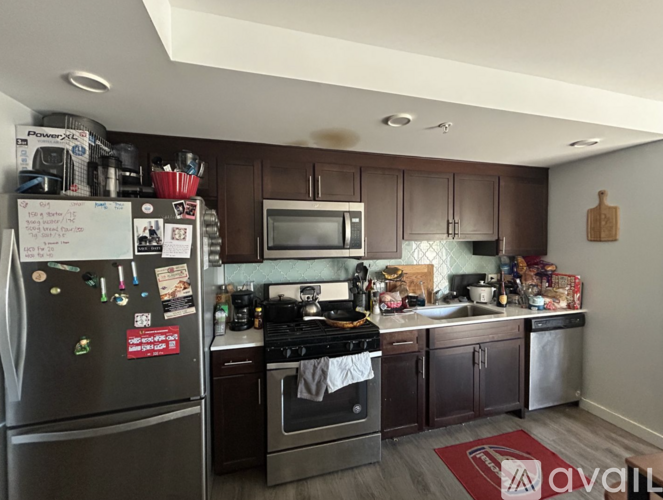 A kitchen with a refrigerator, oven, microwave, and dishwasher.