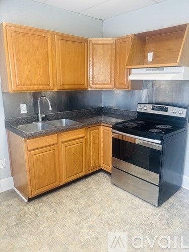 A kitchen with wooden cabinets and a stainless steel oven.
