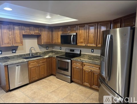 A kitchen with wooden cabinets and stainless steel appliances.
