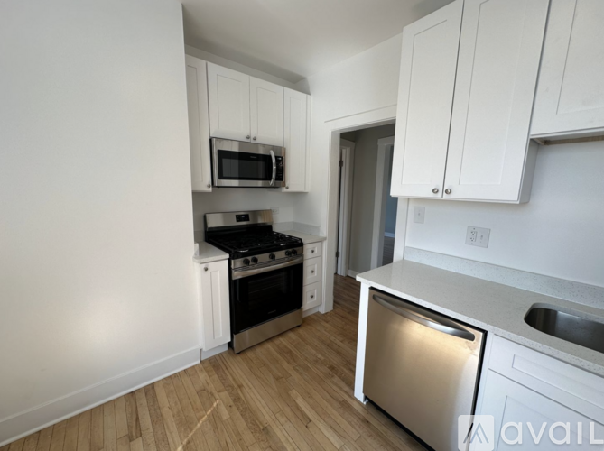 A kitchen with white cabinets and a stainless steel dishwasher.