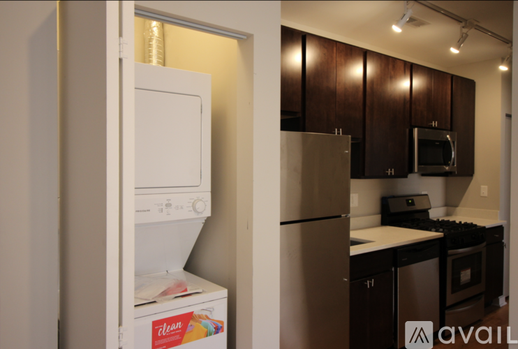 A kitchen with a white dishwasher and a silver refrigerator.