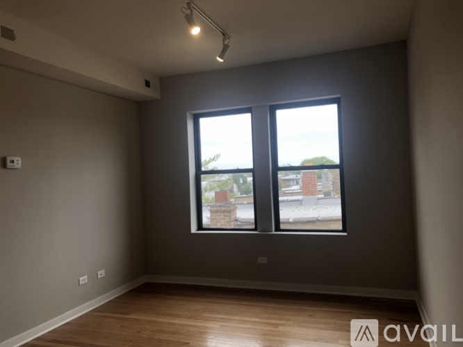A room with a large window and wooden flooring.