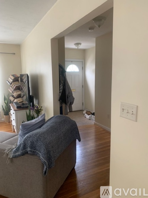 A living room with a couch and a doorway leading to another room.