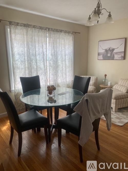 A dining room with a glass table and chairs.