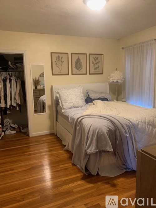 A bedroom with a bed, a wardrobe, and pictures on the wall.