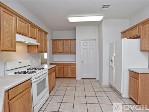 A kitchen with wooden cabinets and white appliances.