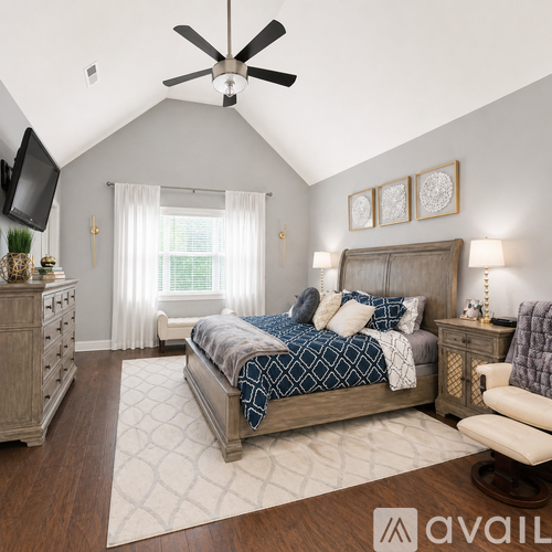 A bedroom with a large bed and a ceiling fan.