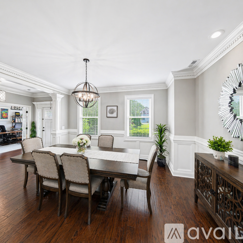 A dining room with a wooden table and chairs.