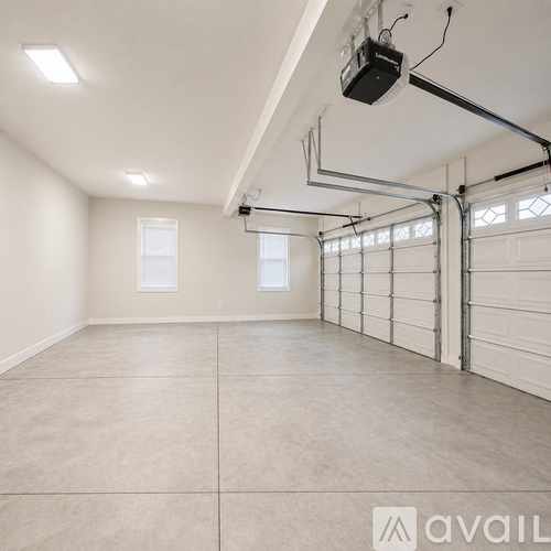 A spacious garage with a white ceiling and a closed white garage door.