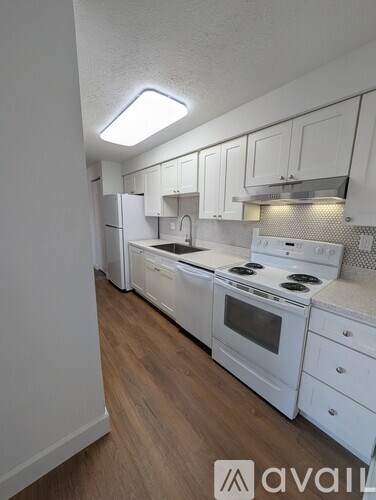 A kitchen with white appliances and cabinets.