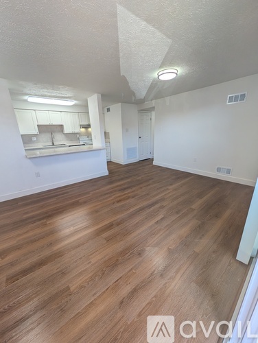 A room with wooden flooring and white walls.