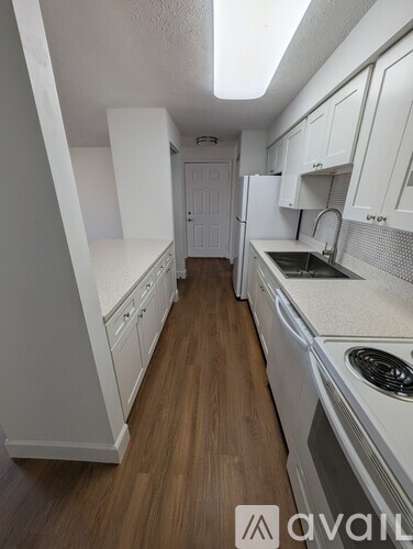 A kitchen with white cabinets and a white dishwasher.