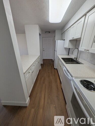A kitchen with white cabinets and a white dishwasher.