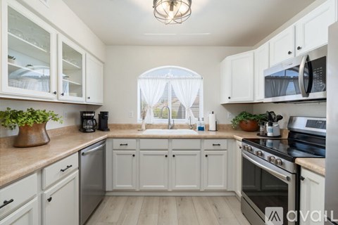 A kitchen with white cabinets and a wooden countertop.