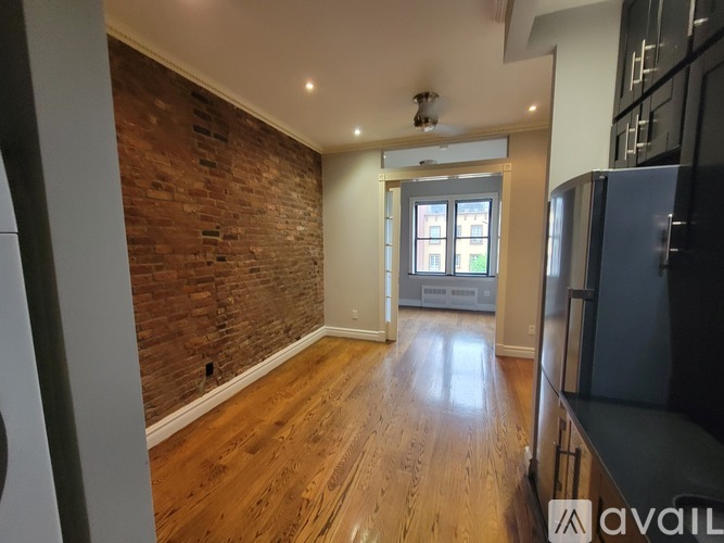 A room with a brick wall and wooden flooring.
