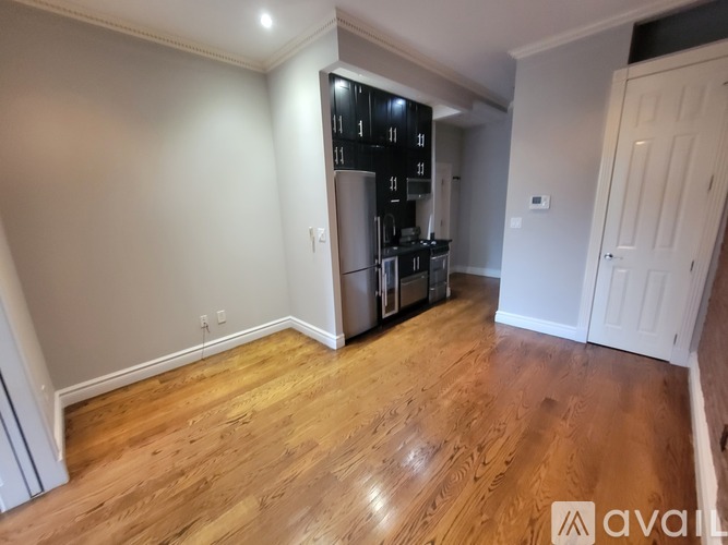 A kitchen area with wooden floors and a white door.