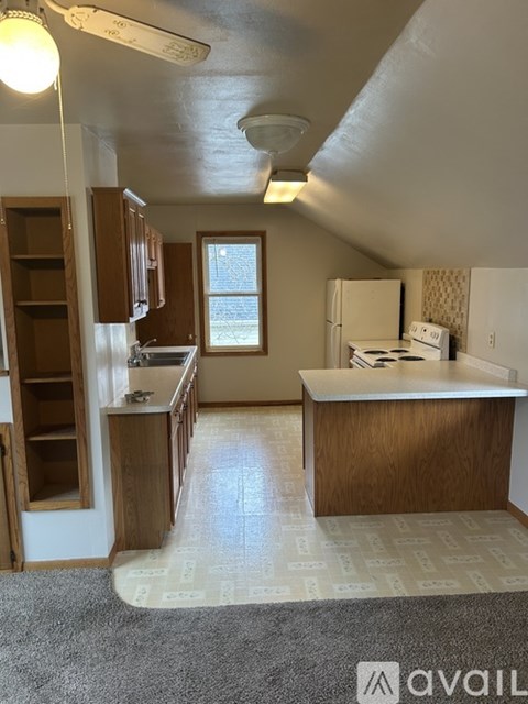A kitchen with wooden cabinets and a white fridge.