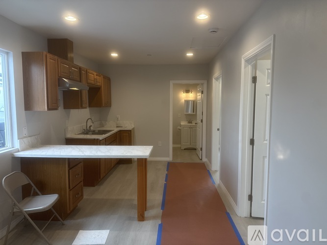A kitchen with a white counter top and wooden cabinets.