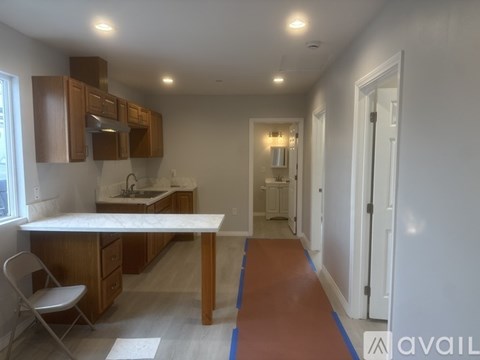 A kitchen with a white counter top and wooden cabinets.