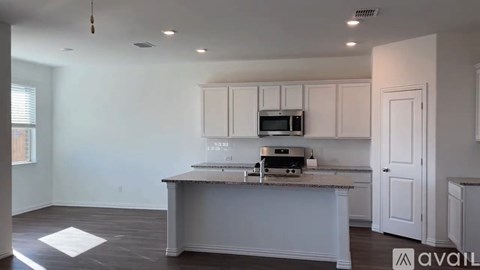A kitchen with a microwave, oven, and cabinets.