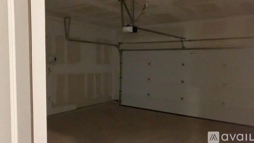 A sparsely furnished room with a white door and a window.