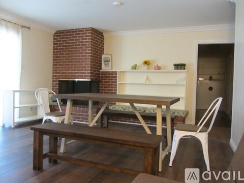 A dining room with a brick chimney and a wooden table.