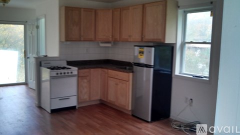 A kitchen with wooden cabinets and a white stove.