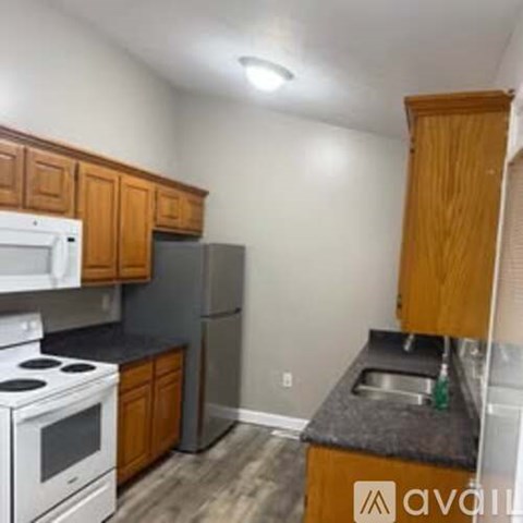 A kitchen with white appliances and wooden cabinets.