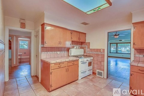 A kitchen with a skylight and a tile floor.
