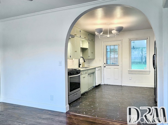 A kitchen with a stove top oven and a refrigerator.