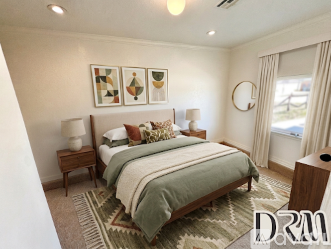A bedroom with a large bed and a rug on the floor.