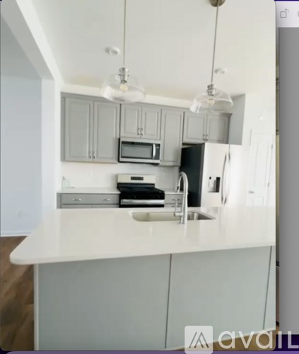 A kitchen with white cabinets and a white countertop.