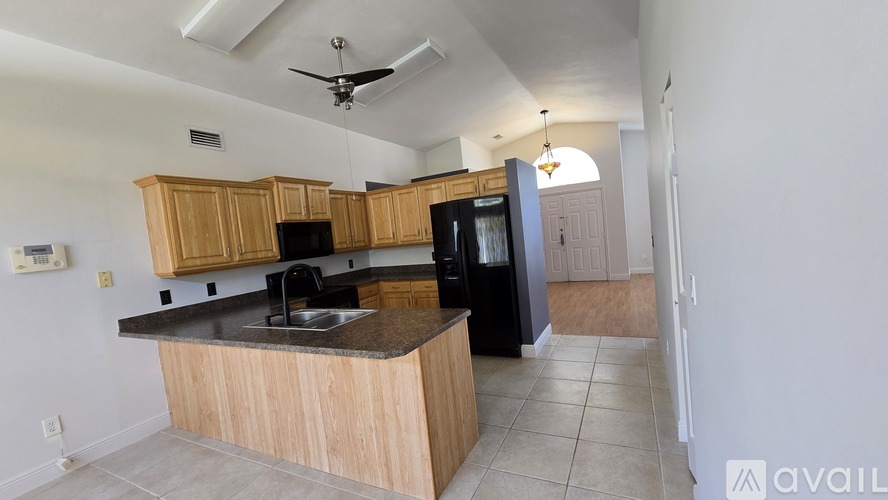 A kitchen with wooden cabinets and black appliances.