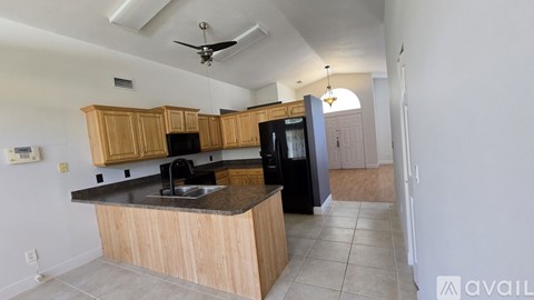 A kitchen with wooden cabinets and black appliances.