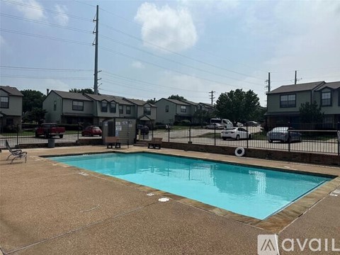 A swimming pool in a residential area with houses in the background.