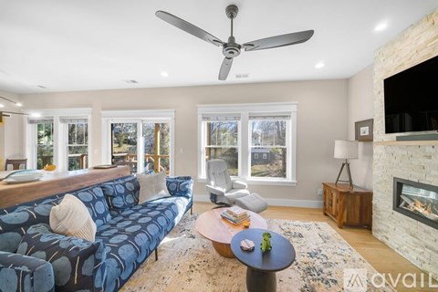 A living room with a blue couch and a fireplace.