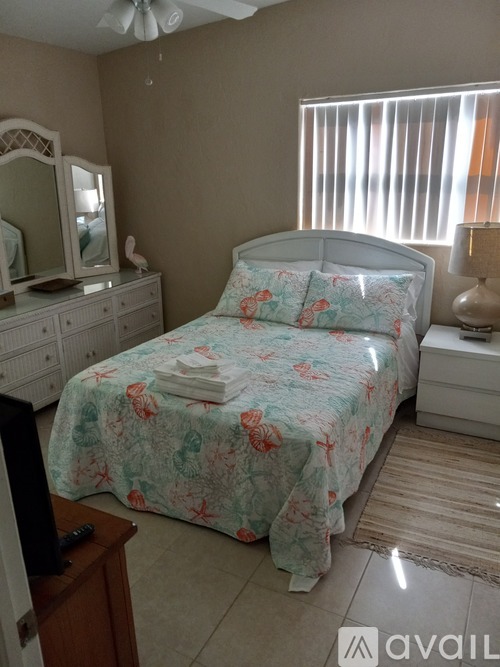 A bedroom with a bed, dresser, and mirror.