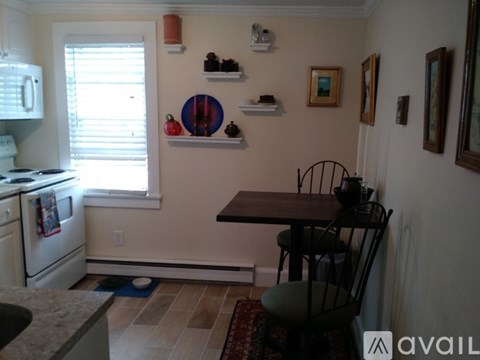 A kitchen with a table and chairs.