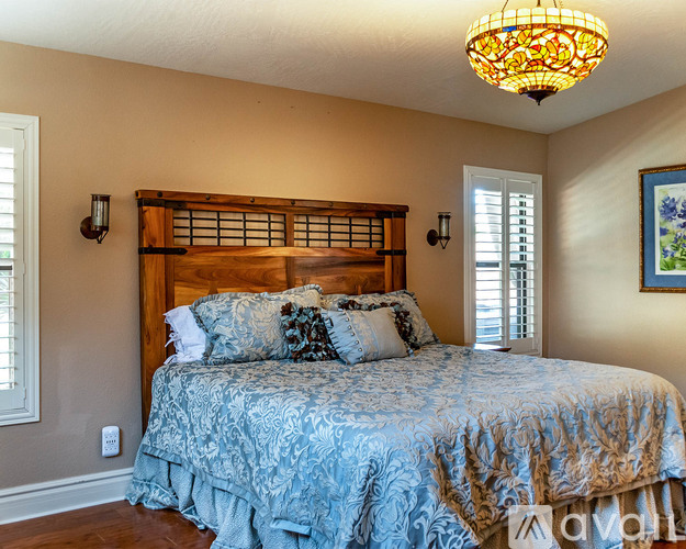 A bedroom with a bed and a painting on the wall.