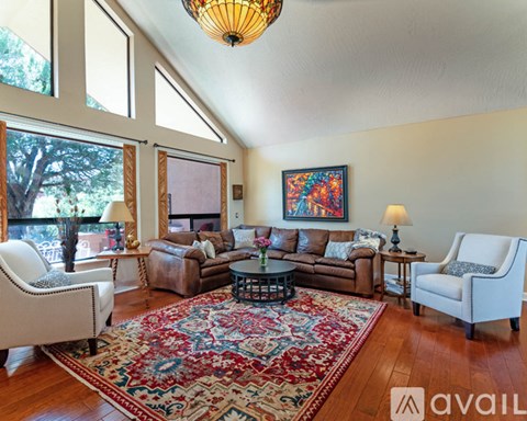 A living room with a rug and a painting on the wall.